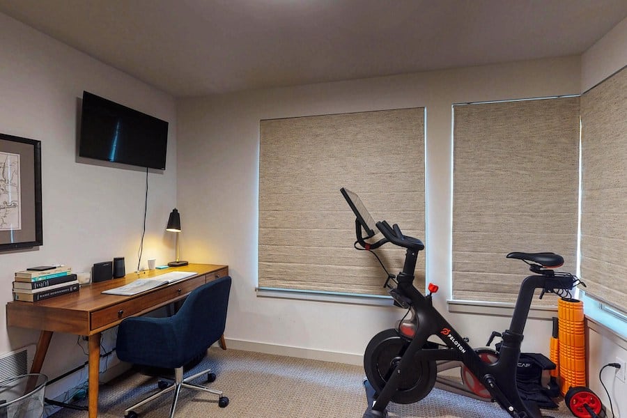 home office with desk and peloton bike