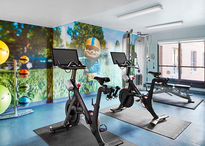 two peloton bikes in front of mural wall at graduate annapolis hotel